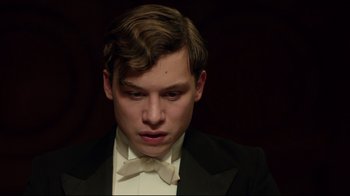 Movie still from “An Inspector Calls” (2015), directed by Raymond Pak-Ming Wong – A young man in a suit and bow tie; Close Up shot, Low angle