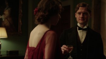 Movie still from “An Inspector Calls” (2015), directed by Raymond Pak-Ming Wong – A man and a woman standing next to each other holding wine glasses; Medium shot, Over the shoulder angle