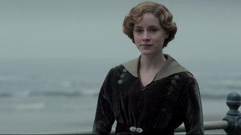 Movie still from “An Inspector Calls” (2015), directed by Raymond Pak-Ming Wong – A woman in a brown dress standing in front of a body of water; Close Up shot, Low angle