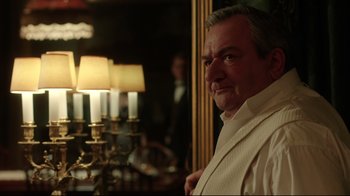 Movie still from “An Inspector Calls” (2015), directed by Raymond Pak-Ming Wong – A man standing in front of a mirror in a room; Close Up shot, Over the shoulder angle