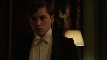 Movie still from “An Inspector Calls” (2015), directed by Raymond Pak-Ming Wong – A young man in a tuxedo standing in a room; Close Up shot, Low angle