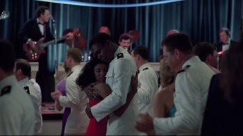 Movie still from “An Officer and a Gentleman” (1982), directed by Taylor Hackford – A man and a woman hugging in front of a group of people; Medium shot, Over the shoulder angle
