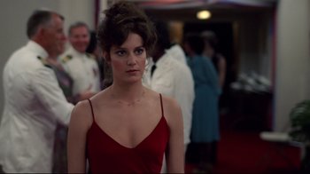 Movie still from “An Officer and a Gentleman” (1982), directed by Taylor Hackford – A woman in a red dress standing next to other people; Medium shot, Over the shoulder angle