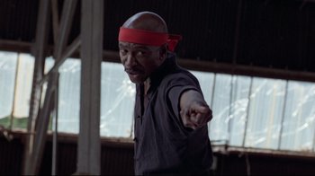 Movie still from “An Officer and a Gentleman” (1982), directed by Taylor Hackford – An older man wearing a red head band and pointing; Medium shot, Low angle