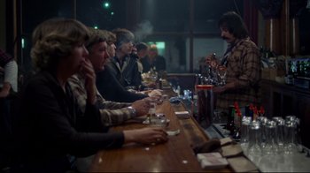 Movie still from “An Officer and a Gentleman” (1982), directed by Taylor Hackford – A group of men sitting at a bar drinking; Wide shot, Over the shoulder angle