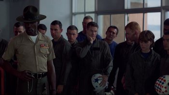 Movie still from “An Officer and a Gentleman” (1982), directed by Taylor Hackford – A group of men standing next to each other in a room; Medium shot, Over the shoulder angle