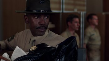 Movie still from “An Officer and a Gentleman” (1982), directed by Taylor Hackford – A man in a hat is holding a pair of shoes; Close Up shot, Low angle