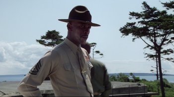 Movie still from “An Officer and a Gentleman” (1982), directed by Taylor Hackford – A man in a hat and uniform standing next to another man; Medium shot, Low angle