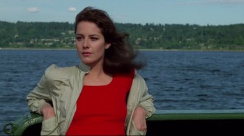 Movie still from “An Officer and a Gentleman” (1982), directed by Taylor Hackford – A woman in a red shirt and a jacket by a body of water; Medium shot, Low angle