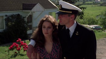 Movie still from “An Officer and a Gentleman” (1982), directed by Taylor Hackford – A man and a woman standing next to each other; Medium shot, Low angle