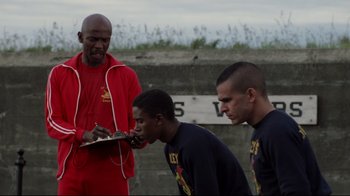 Movie still from “An Officer and a Gentleman” (1982), directed by Taylor Hackford – A group of young men standing next to each other on a field; Medium shot, Low angle