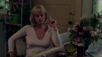 Movie still from “An Officer and a Gentleman” (1982), directed by Taylor Hackford – A woman sitting at a table with a cigarette in her mouth; Medium shot, Low angle