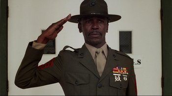 Movie still from “An Officer and a Gentleman” (1982), directed by Taylor Hackford – A man in uniform saluting in front of a wall; Medium shot, Low angle