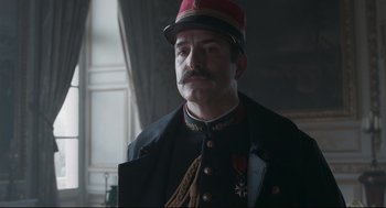Movie still from “An Officer and a Spy” (2019), directed by Roman Polanski – A person wearing a uniform and a hat; Close Up shot, Low angle