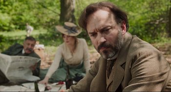 Movie still from “An Officer and a Spy” (2019), directed by Roman Polanski – A man and a woman sitting in the woods; Medium shot, Over the shoulder angle