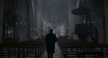 Movie still from “An Officer and a Spy” (2019), directed by Roman Polanski – A man standing in the middle of an empty church; Extreme Wide shot, High angle