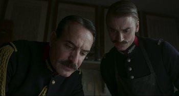 Movie still from “An Officer and a Spy” (2019), directed by Roman Polanski – Two men in military uniforms looking at each other; Close Up shot, Low angle