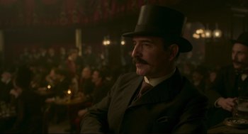 Movie still from “An Officer and a Spy” (2019), directed by Roman Polanski – A man in a suit and top hat in front of a crowd of onlookers; Medium shot, Low angle