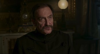 Movie still from “An Officer and a Spy” (2019), directed by Roman Polanski – A person wearing a suit; Close Up shot, Over the shoulder angle