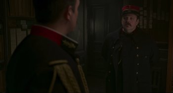 Movie still from “An Officer and a Spy” (2019), directed by Roman Polanski – A man in a uniform looking at another man in a uniform looking in the mirror; Medium shot, Over the shoulder angle