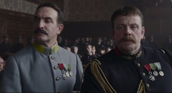 Movie still from “An Officer and a Spy” (2019), directed by Roman Polanski – Two men in military garb standing next to each other; Close Up shot, Low angle