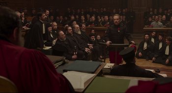 Movie still from “An Officer and a Spy” (2019), directed by Roman Polanski – A group of people sitting in front of a microphone; Medium shot, High angle