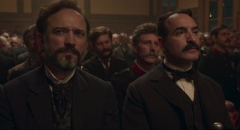 Movie still from “An Officer and a Spy” (2019), directed by Roman Polanski – A group of men standing next to each other in a room; Close Up shot, Low angle