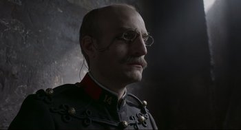 Movie still from “An Officer and a Spy” (2019), directed by Roman Polanski – A man in a military uniform wearing glasses; Close Up shot, Low angle