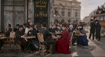 Movie still from “An Officer and a Spy” (2019), directed by Roman Polanski – A group of people sitting at tables outside of a cafe; Extreme Wide shot, High angle
