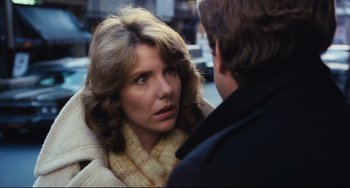 A woman in a yellow jacket talking to a man in a black jacket