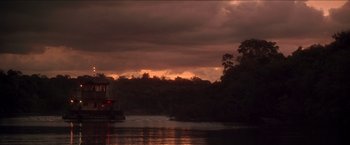 Movie still from “Anaconda” (1997), directed by Luis Llosa – A body of water near a forest during a cloudy day; Extreme Wide shot, Low angle