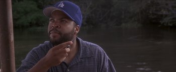 Movie still from “Anaconda” (1997), directed by Luis Llosa – A man in a blue hat is holding a cell phone; Close Up shot, Low angle