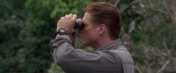 Movie still from “Anaconda” (1997), directed by Luis Llosa – A man looking through a pair of binoculars; Close Up shot, High angle