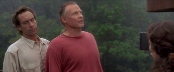 Movie still from “Anaconda” (1997), directed by Luis Llosa – A man in a red shirt looking up at the sky; Close Up shot, Low angle