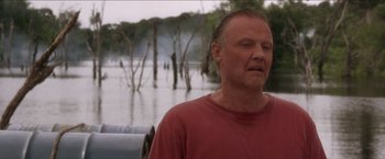 Movie still from “Anaconda” (1997), directed by Luis Llosa – A man standing in front of a body of water; Close Up shot, Low angle