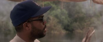 Movie still from “Anaconda” (1997), directed by Luis Llosa – A person wearing glasses and a hat; Close Up shot, Over the shoulder angle