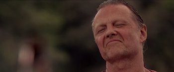 Movie still from “Anaconda” (1997), directed by Luis Llosa – An older man with his eyes closed; Close Up shot, Low angle