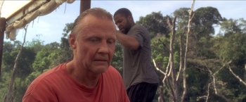 Movie still from “Anaconda” (1997), directed by Luis Llosa – A man with a bald head is looking at another man with a bald head; Close Up shot, Low angle