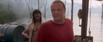 Movie still from “Anaconda” (1997), directed by Luis Llosa – A man in a red t - shirt standing next to another man in a white shirt; Medium shot, Low angle