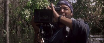 Movie still from “Anaconda” (1997), directed by Luis Llosa – A man holding a video camera up to his face; Close Up shot, Over the shoulder angle