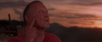 Movie still from “Anaconda” (1997), directed by Luis Llosa – A person holding his hand up to his ear; Extreme Close Up shot, Low angle