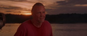 Movie still from “Anaconda” (1997), directed by Luis Llosa – A person wearing a red shirt near a body of water; Close Up shot, Low angle