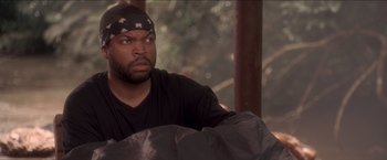 Movie still from “Anaconda” (1997), directed by Luis Llosa – A man with a bandanna on his head is looking at something; Close Up shot, Over the shoulder angle