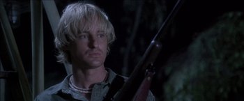 Movie still from “Anaconda” (1997), directed by Luis Llosa – A man holding a rifle in a dark forest at night; Close Up shot, Low angle