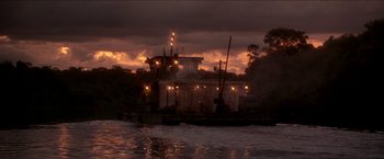 Movie still from “Anaconda” (1997), directed by Luis Llosa – A boat in a body of water at night; Extreme Wide shot, Low angle