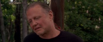 Movie still from “Anaconda” (1997), directed by Luis Llosa – A person wearing a black t - shirt; Close Up shot, Low angle