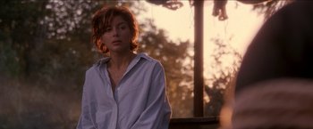 Movie still from “Anaconda” (1997), directed by Luis Llosa – A woman standing in front of a tree in the sunlight; Close Up shot, Over the shoulder angle