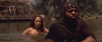 Movie still from “Anaconda” (1997), directed by Luis Llosa – A man and a woman swimming in a body of water; Medium shot, Low angle