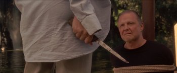 Movie still from “Anaconda” (1997), directed by Luis Llosa – A man holding a knife in front of another man; Close Up shot, Over the shoulder angle