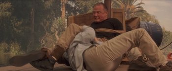 Movie still from “Anaconda” (1997), directed by Luis Llosa – A man is tied to a chair with a rope around his neck; Medium shot, Over the shoulder angle